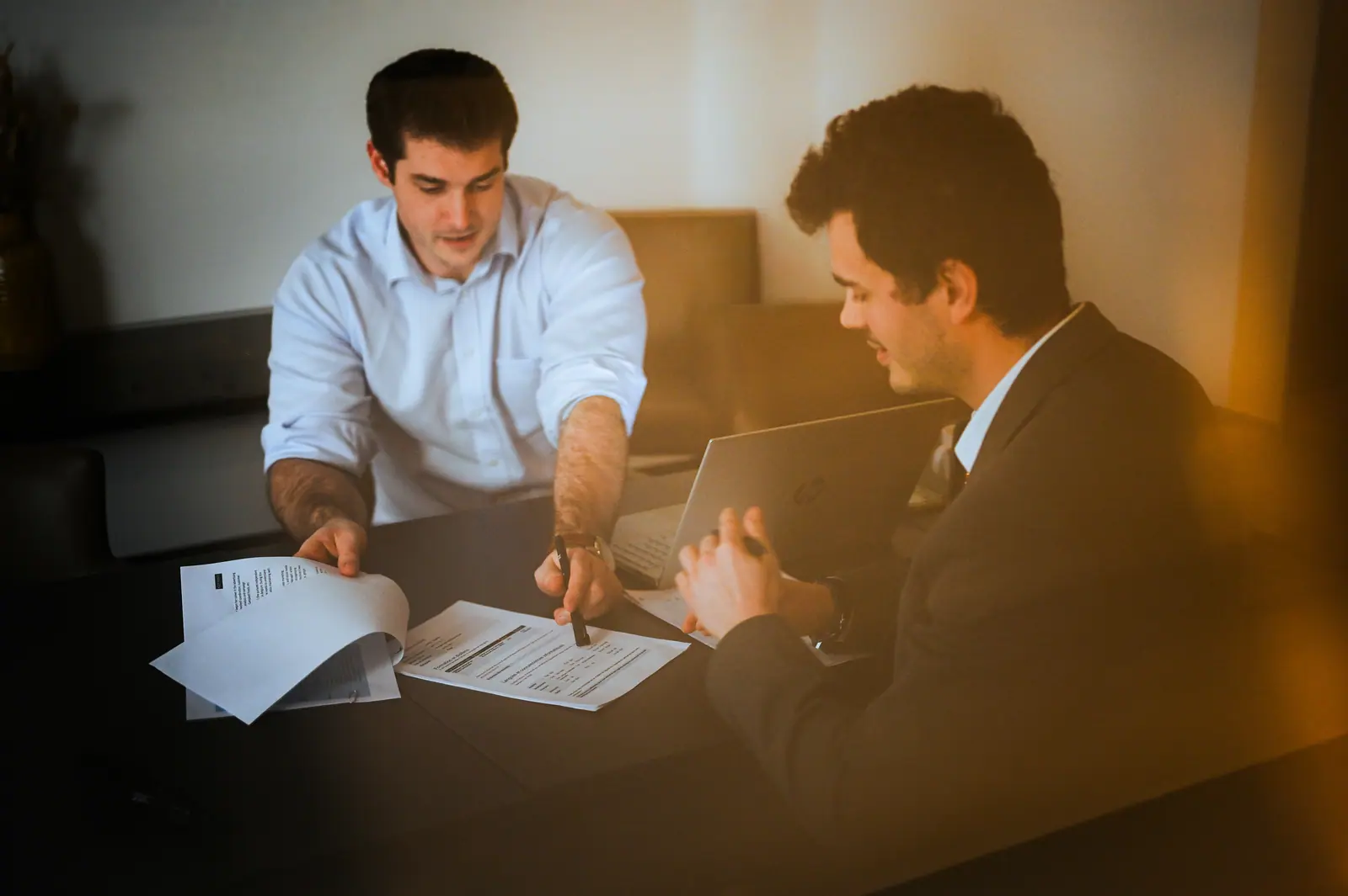 Two consultants reviewing documents together in warm light